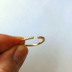 Like new gold tone dainty ring with prong set stones, open front design, size 6